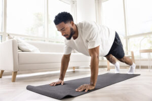 Focused athletic strong African man doing pushups morning exercises